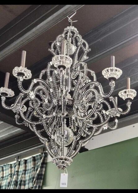 Elegant vintage crystal chandelier with ornate metal scrollwork, nine candle-style arms, and sparkling crystal accents—perfect for vintage interior design lovers.