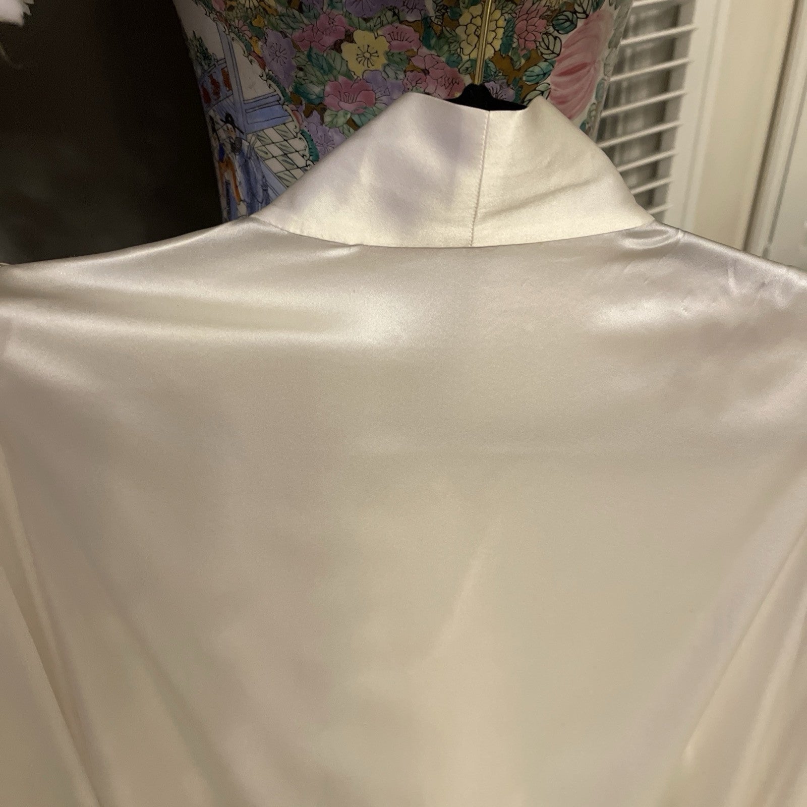 Elegant cream silk blouse by The Vampire’s Wife, featuring a high neck with tie detail, long puffed sleeves, and ruffled cuffs—perfect for designer vintage fashion neck behind